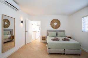 een witte slaapkamer met een bed en een spiegel bij Appartement James in Jan Thiel