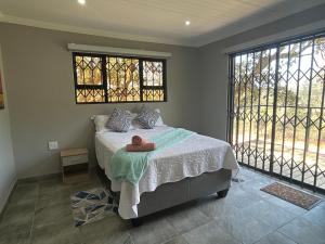 a bedroom with a bed and two windows at The Bush Baby Accommodation in Amanzimtoti