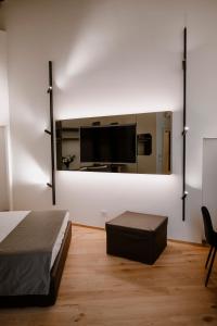 una camera con letto e TV a parete di Palazzo Garibaldi - Boutique Suites a Barletta