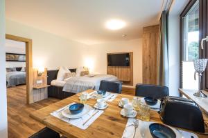 a dining room with a table and a bedroom at Appartements by Hofer in Kaprun