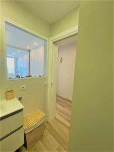 a bathroom with a sink and a window and a hallway at Holidays in My Barra Canteras in Las Palmas de Gran Canaria
