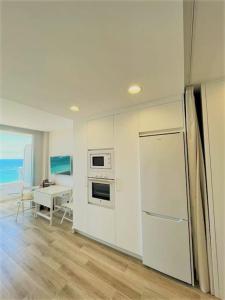 a kitchen with a refrigerator and a dining room with a table at Holidays in My Barra Canteras in Las Palmas de Gran Canaria