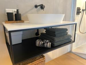 a shelf with a sink and a stack of towels at B&B Het Zwarte Schaap in Albergen