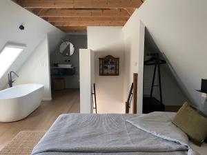 a bedroom with a tub and a bed and a sink at B&B Het Zwarte Schaap in Albergen