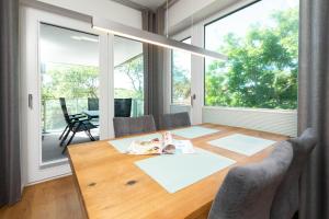 comedor con mesa de madera y ventanas grandes en Villa Sohn Deck7, en Juist