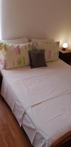 duże białe łóżko z wieloma poduszkami w obiekcie Apartments Srhoj w mieście Stari Grad