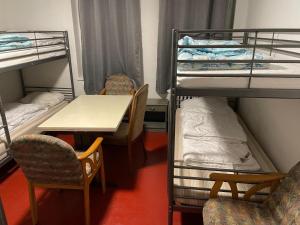 a room with bunk beds and a table and chairs at Hostel Sofia in Nürnberg