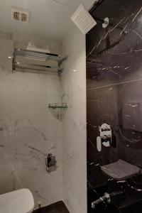 a bathroom with a black and white marble shower at Hotel Amber Suite Near Mumbai Airport in Mumbai