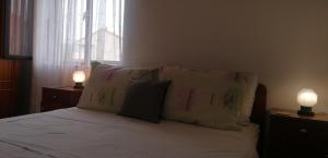 1 dormitorio con 1 cama con almohadas y 2 lámparas en Apartments Srhoj, en Stari Grad