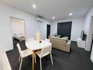 a living room with a white table and a couch at Lightsview Entire Apt 9 KM from CBD in Broadview
