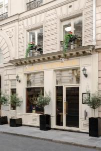 un magasin devant un bâtiment avec des plantes en pot dans l'établissement Meliá Paris Vendôme, à Paris