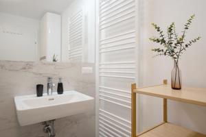bagno bianco con lavandino e specchio di easy flat Villach main plaza a Villach