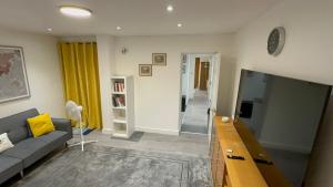 a living room with a couch and a flat screen tv at Entire One Double Bedroom apartment in London