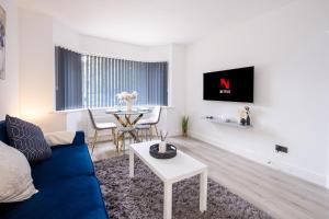 een woonkamer met een blauwe bank en een tafel bij Spacious 2 Bed Home with FREE PARKING and Netflix in Maidenhead