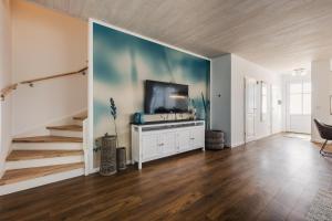 FuhlendorfにあるFerienhäuser Baltic Lagoon Haus 14cの壁にテレビが取り付けられたリビングルーム