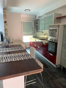 - une cuisine avec une table en bois et un four micro-ondes dans l'établissement Precioso apartamento con bañera hidromasaje, à Sopelana