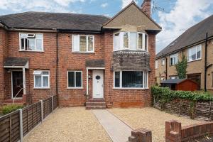a brick house with a white door and a fence at Spacious 2 Bed Home with FREE PARKING and Netflix in Maidenhead