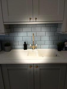 a kitchen sink with a faucet on top of it at Newly Renovated 3 Bedroom Victorian Detached House in Bournemouth