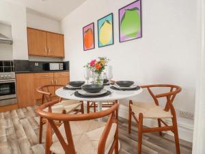 a kitchen with a table and chairs with flowers on it at 53A Princes Crescent in Morecambe