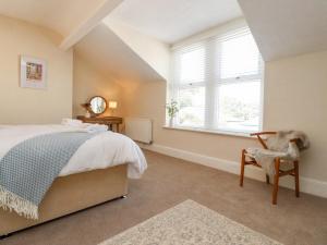 a bedroom with a bed and a chair and a window at 53A Princes Crescent in Morecambe