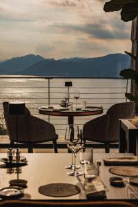a table with two chairs and a table with wine glasses at Cape of Senses in Torri del Benaco