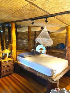 a bedroom with a bed in a log cabin at Sea View Palm Villa - Tree House in Haad Yao