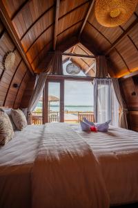 uma cama grande num quarto com uma janela grande em HIMA Bungalows em Lagudri