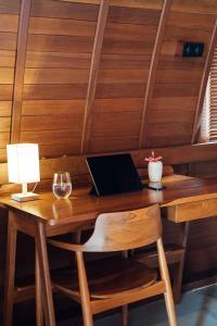 a wooden table with a laptop and a lamp on it at HIMA Bungalows in Lagudri