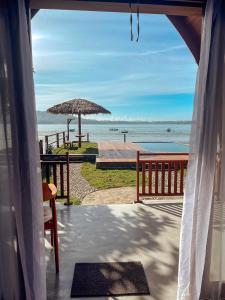 Blick auf den Strand von einer Veranda mit Sonnenschirm in der Unterkunft HIMA Bungalows in Lagudri