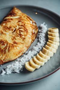 um prato de comida com tarte e fatias de banana em HIMA Bungalows em Lagudri