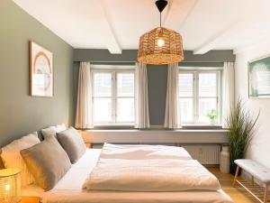 a bedroom with a large bed in front of two windows at Family-Friendly Flat Near Tivoli Gardens in Copenhagen