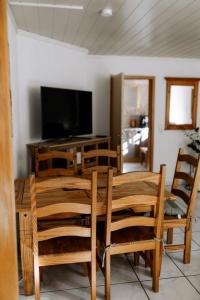 una sala da pranzo con tavolo, sedie e TV di Moderne Landwohnung - in Toplage a Gottmadingen