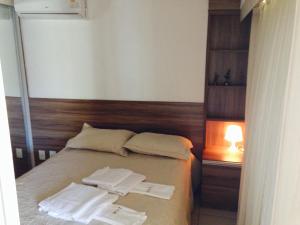 1 dormitorio con 1 cama con 2 toallas en Beach Class Residence Fortaleza, en Fortaleza