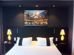 a bedroom with a bed with a tv on the wall at Golf Hotel Colvert - Piscine extérieure et Room Service in Levernois +34 photos