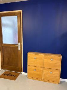 ノワジー・ル・セックにあるDuplex Azulのベッドルーム1室(木製のドア、ドレッサー、青い壁付)