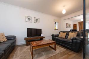 a living room with two couches and a television at Parf’s Place, Troedyrhiw near Bike Park Wales in Troed-y-rhiw