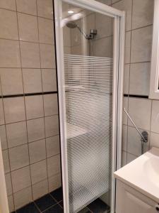 a shower with a glass door in a bathroom at Sjøgløtt Gjestgiveri in Kristiansand