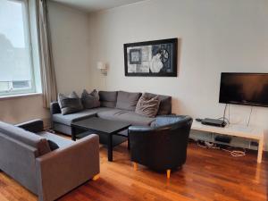 uma sala de estar com um sofá e uma televisão de ecrã plano em Sjøgløtt Gjestgiveri em Kristiansand