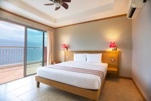 a bedroom with a bed and a large window at Pinnacle Koh Tao Resort in Ko Tao
