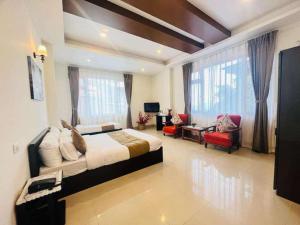 Un dormitorio con una cama grande y una sala de estar en Maplewood Hotel & Spa, en Gangtok