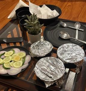 uma mesa com uma bandeja com pratos e utensílios em The Blossom Glee em Bhīm Tāl