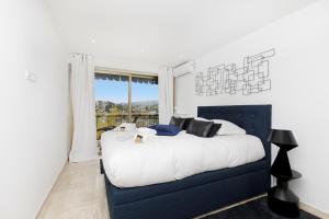 a bedroom with a large bed and a window at Appartement à 2 pas du golf in Mandelieu-la-Napoule