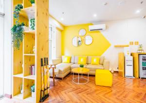 sala de estar con sofá y pared amarilla en Bloom Hotel - Heritage Walk en Amritsar