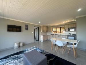 a kitchen and dining room with a table and chairs at The Bush Baby Accommodation in Amanzimtoti