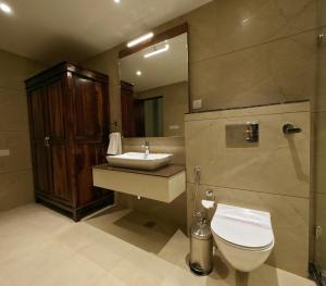 Hotel Chandra Raj Mahal في بيكانير: حمام مع حوض ومرحاض ومرآة
