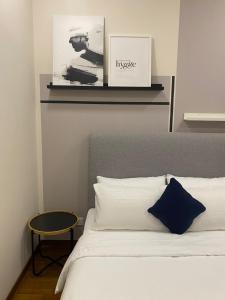 - une chambre avec un lit blanc et un oreiller bleu dans l'établissement Home Resort KLCC by Calm Sojourn, à Kuala Lumpur