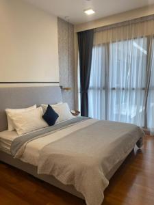 - une chambre avec un grand lit et une grande fenêtre dans l'établissement Home Resort KLCC by Calm Sojourn, à Kuala Lumpur