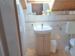 a bathroom with a sink and a toilet at Kismarosi Center Apartman in Kismaros