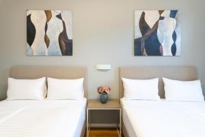 twee bedden in een kamer met schilderijen aan de muur bij Hidden Art Boutique Residence in Praag