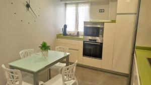 a kitchen with a table and chairs and a refrigerator at Ohana, Apartamento-PARKING PRIVADO GRATIS-CENTRICO-WIFI-ASCENSOR-SIN CUESTAS-82m2 in Bermeo